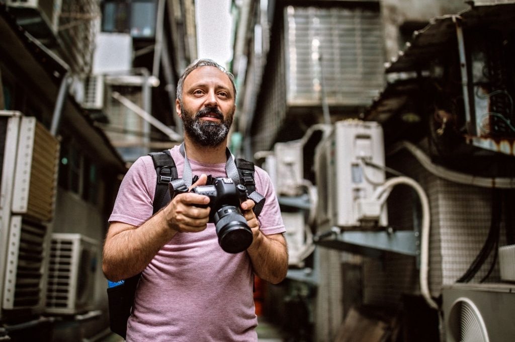 Mid adult photographer in city alley