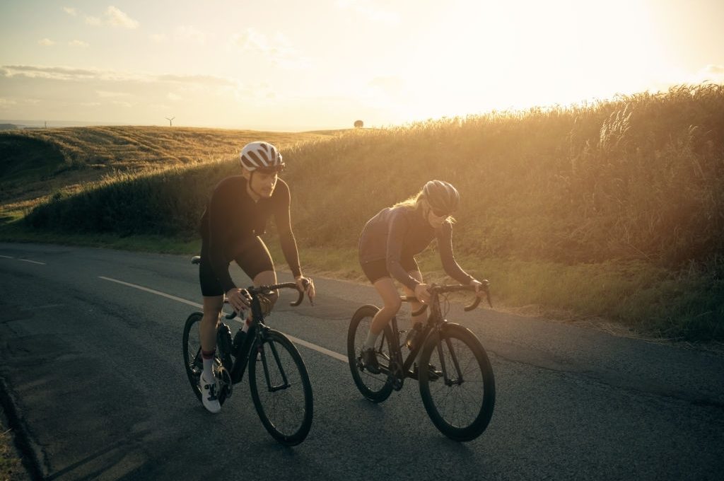 Shot of two cyclists out cycling on a country road