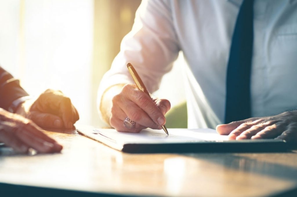 Closeup Businessman signing a contract investment professional document agreement on the table with pen.