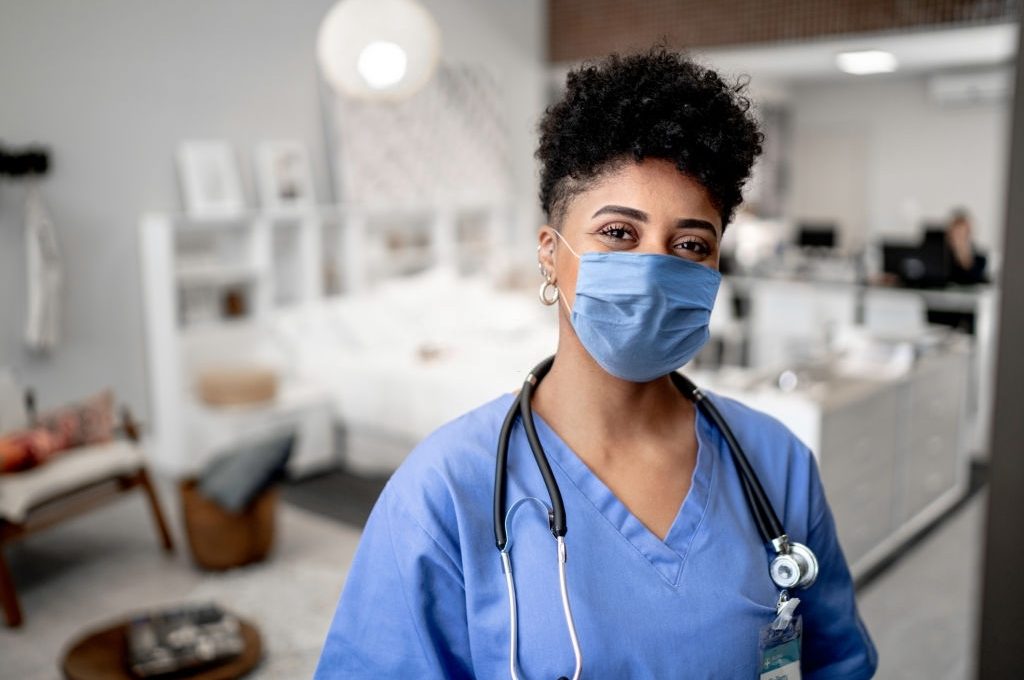 Portrait of a young nurse/doctor on a house call with face mask
